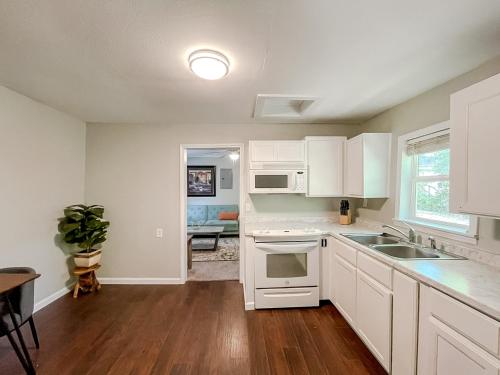 a kitchen with white cabinets and a sink at Sleepover Historic Downtown Springfield Apartments in Springfield