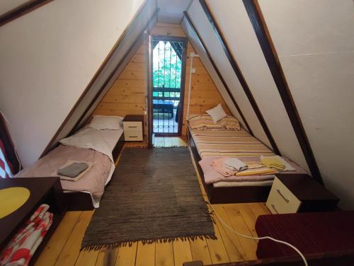 a attic room with two beds and a window at Ovcar banja in Čačak
