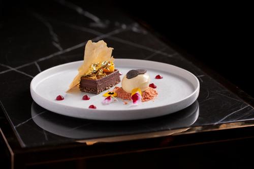 a white plate with a piece of dessert on a table at Fable Auckland, MGallery in Auckland