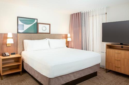 a hotel room with a bed and a flat screen tv at Staybridge Suites - San Bernardino - Loma Linda in San Bernardino