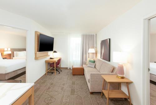 a hotel room with a couch and a bed at Staybridge Suites - San Bernardino - Loma Linda in San Bernardino