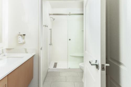 a white bathroom with a shower and a toilet at Staybridge Suites - San Bernardino - Loma Linda in San Bernardino