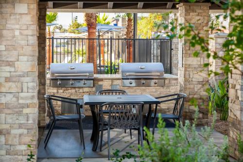 a patio with a table and chairs and a grill at Staybridge Suites - San Bernardino - Loma Linda in San Bernardino