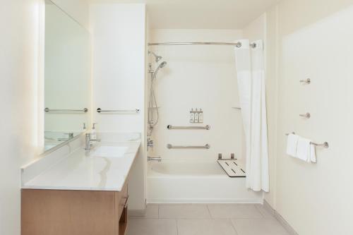 a white bathroom with a shower and a sink at Staybridge Suites - San Bernardino - Loma Linda in San Bernardino