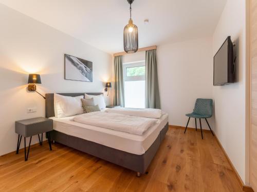 um quarto com uma cama, uma televisão e uma cadeira em Ski Nature Apartment Lungau Top 13 em Mauterndorf