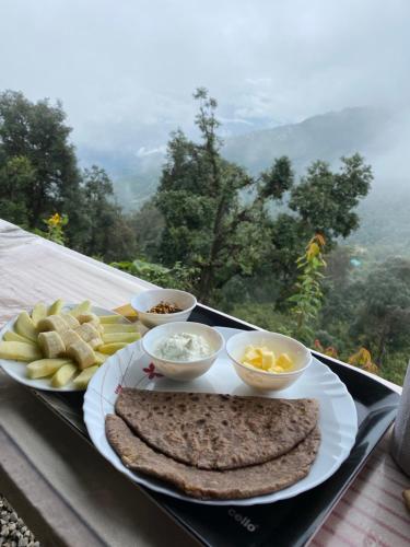 a tray with a plate of food on a table at Ananta Prana in Mussoorie
