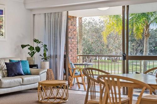 a living room with a couch and a table and chairs at Castaway opposite Clarkes Beach in Byron Bay