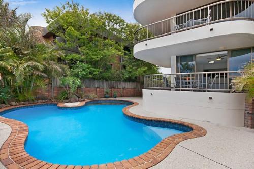 a swimming pool in front of a house at Castaway opposite Clarkes Beach in Byron Bay