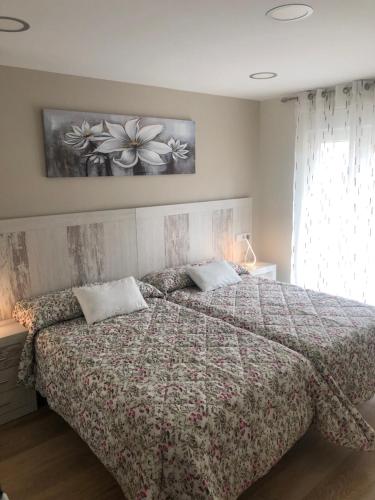 萊昂的住宿－Piso céntrico León 2，一间卧室配有一张带花卉床罩的大床
