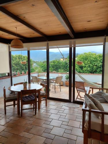 a living room with a table and chairs and a patio at Casa Quinta Mar, Casa de campo en el Tule, Oaxaca. in Santa María del Tule
