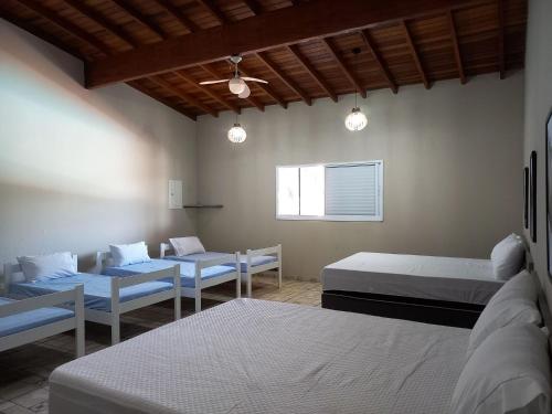 um quarto com três camas e um sofá em Chacara com piscina e muito lazer em Jarinu SP em Jarinu