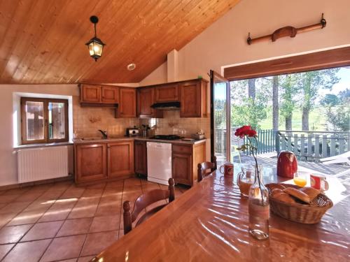 a kitchen with a wooden table and a dining room at Charmant gîte à Saint-Romain-Lachalm avec terrasse et proximité Dunières - FR-1-582-264 in Saint-Romain-Lachalm