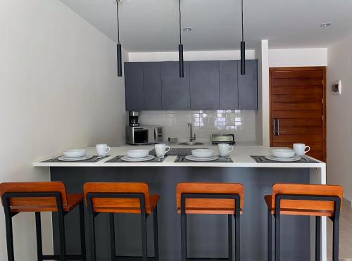 cocina con sillas de color naranja y barra de cocina en Kali Secreto en Jalpan