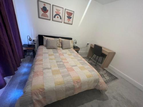 a bedroom with a bed and a desk with a chair at Cheerful Two Bedrooms Town house with free parking in Pembrokeshire