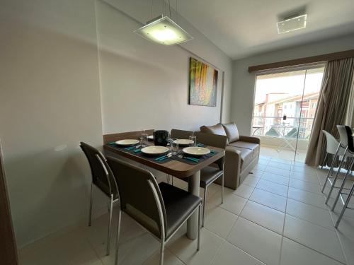 een woonkamer met een eettafel en stoelen bij Flat 501 - Condominio Veredas do Rio Quente - Diferenciado com ar na sala e no quarto in Rio Quente