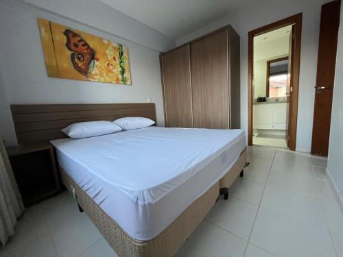 een slaapkamer met een groot bed met witte lakens bij Flat 501 - Condominio Veredas do Rio Quente - Diferenciado com ar na sala e no quarto in Rio Quente