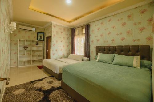a bedroom with two beds and a window at Hakata Lejja near Natural Hot spring in Batu-Batu