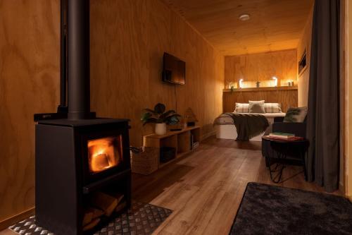 a living room with a wood stove in a room at Luxury Container Cabin in Masterton
