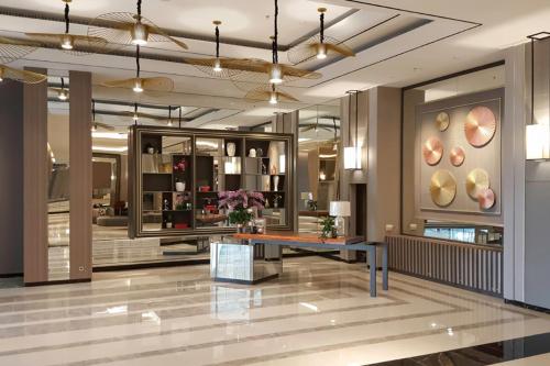 a lobby with a table in the middle of a building at Apartment Anderson Benson Orchard Tanglin Tower di atas Pakuwon Mall Surabaya Barat in Lontar