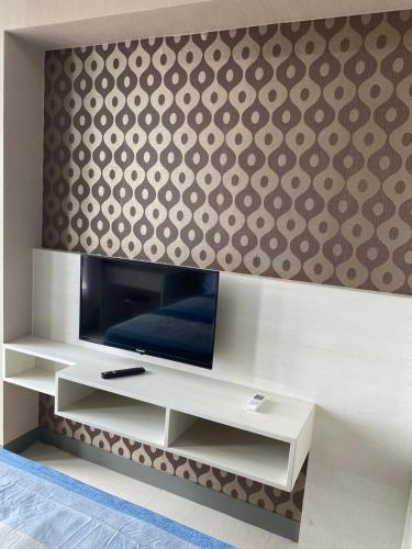 a flat screen tv sitting on top of a wall at Apartment Anderson Benson Orchard Tanglin Tower di atas Pakuwon Mall Surabaya Barat in Lontar