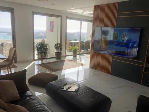 a living room with a couch and a flat screen tv at New Luxury Apartment Sea View in Agadir