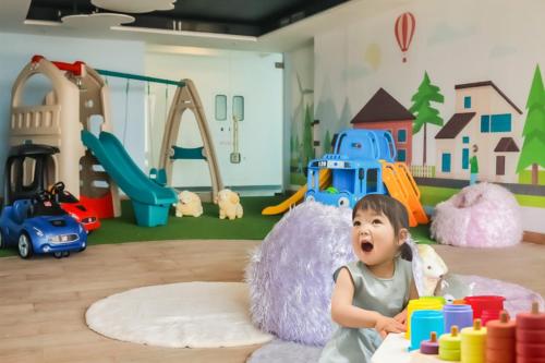a baby sitting in a play room with toys at Apartment Anderson Benson Orchard Tanglin Tower di atas Pakuwon Mall Surabaya Barat in Lontar