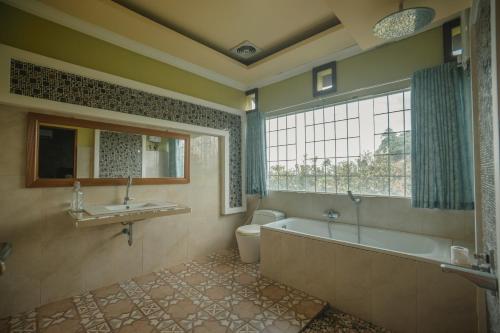 a bathroom with a tub and a toilet and a sink at Hakata Lejja near Natural Hot spring in Batu-Batu
