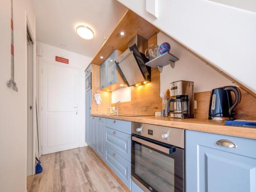 une cuisine avec des armoires bleues et un comptoir dans l'établissement Sea View Apartment with Style, à Saint-Vaast-la-Hougue