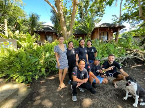 a group of people posing for a picture with a dog at La Tortue Diving Resort Dauin in Dauin