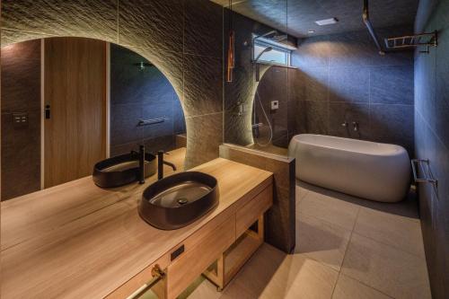 a bathroom with a sink and a tub and a toilet at KeiU-Yakushima Luxury Guest House in Yakushima