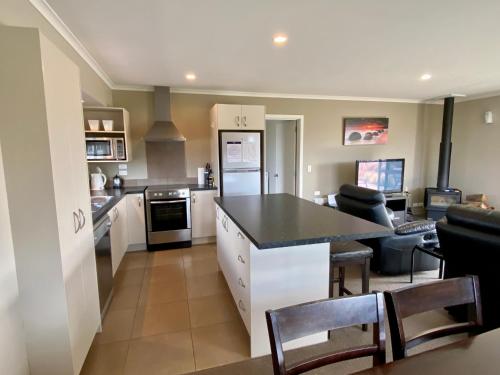 a kitchen and living room with a table and chairs at Rocking it On Rhoboro in Twizel