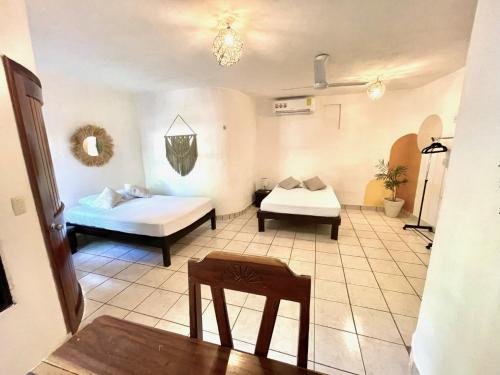 a room with two beds and a table in it at Casa Umay in Bacalar