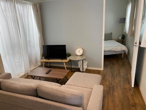a living room with a couch and a bed and a mirror at ホテルトーマス牧志 in Naha