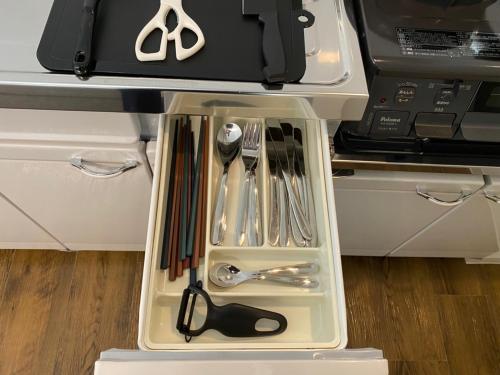 a drawer filled with utensils in a kitchen at ホテルトーマス牧志 in Naha