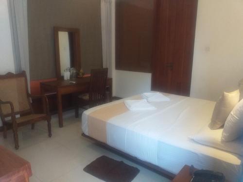 a bedroom with a bed and a dining room with a table at De Mansion Hotels in Katugastota