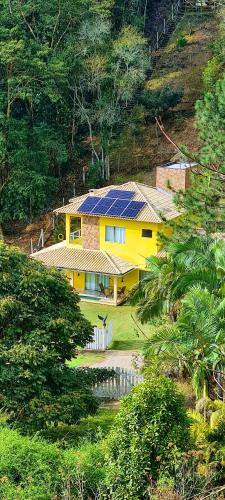 a yellow house with solar panels on top of it at Casa Amarela da Uruçu in Aracê