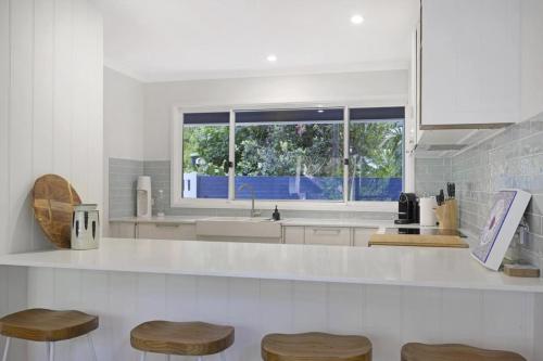 Macmasters BeachにあるFamily Friendly Beach House - 5mins walk to the beachのシンクと窓のある白いキッチン