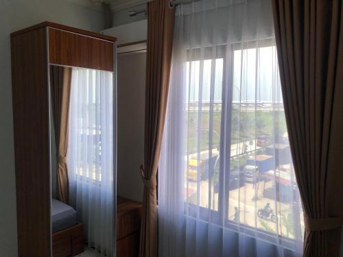 a bedroom with a window with a view of a building at Bening Asri Guesthouse in Gombolpaya