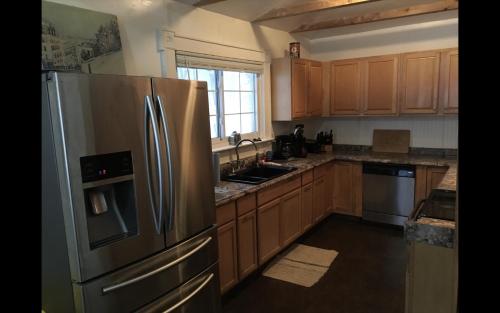 a kitchen with wooden cabinets and a stainless steel refrigerator at Near Chiefs and Royals Stadium - 4 beds in Independence