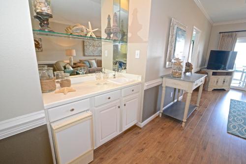 a bathroom with a sink and a desk in a room at Dolphin Harbor 3C in Orange Beach