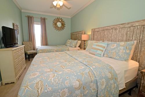 a bedroom with two beds and a television in it at Dolphin Harbor 3C in Orange Beach