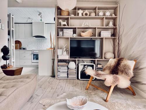 a living room with a couch and a tv at Villa Blanc in Oneroa