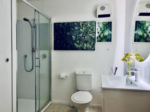a bathroom with a shower and a toilet and a sink at Villa Blanc in Oneroa