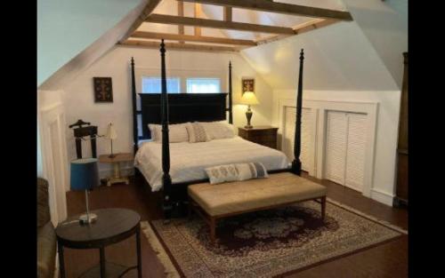 a bedroom with a large bed and a bench at Near Chiefs and Royals Stadium - 4 beds in Independence