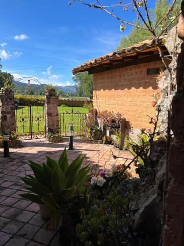 a garden with a stone building and a fence at Casona Ananda in Firavitoba