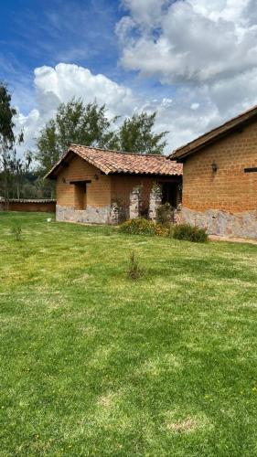 an old brick building in a field of grass at Casona Ananda in Firavitoba