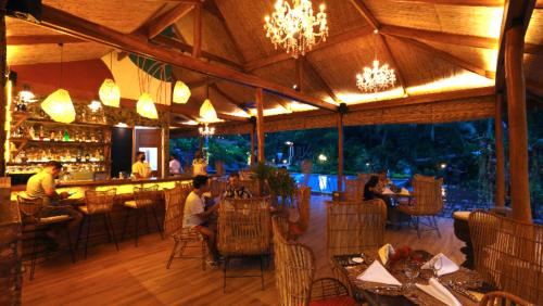 un ristorante con persone sedute ai tavoli e un bar di Lihim Resorts a El Nido