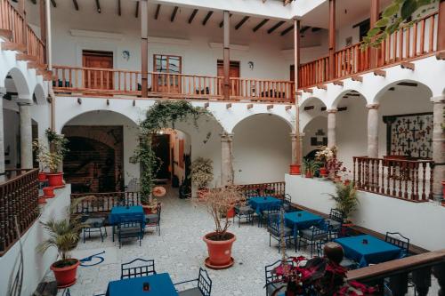 un patio con mesas azules y sillas en un edificio en Hotel Casa Alquimia en Quito