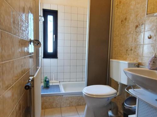 uma casa de banho com um WC, uma banheira e um lavatório. em Holiday home in Willingen in beautiful hilly surroundings em Stryck