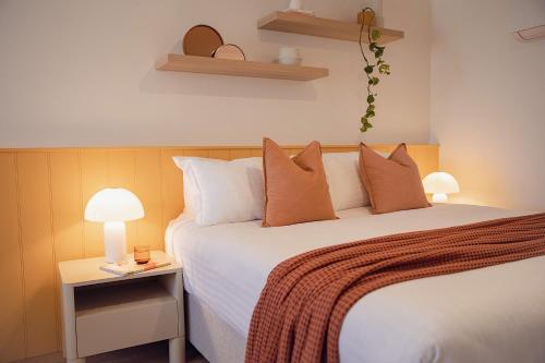 una camera da letto con un grande letto bianco con cuscini di Sunnymead Hotel ad Aireys Inlet